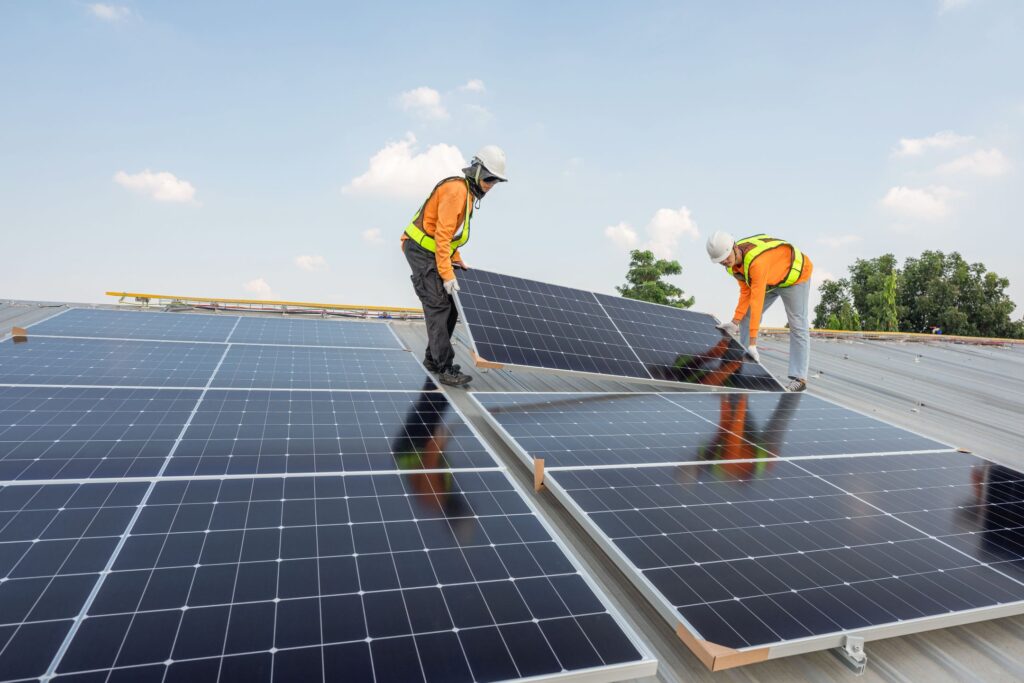 download 6 Technicians installing solar panels on a sloped roof under a clear sky. Sustainable energy setup. | Sky Rye Design Technicians installing solar panels on a sloped roof under a clear sky. Sustainable energy setup.