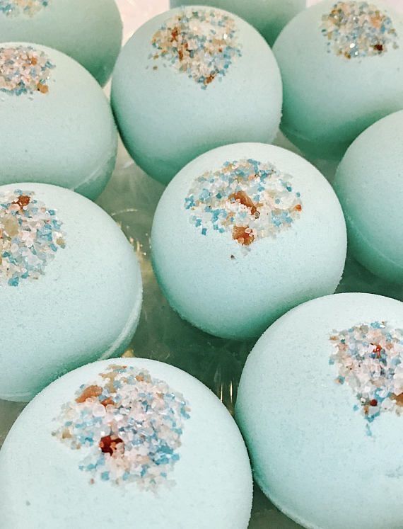 Light blue bath bombs with colorful crystal toppings, perfect for a relaxing spa experience.