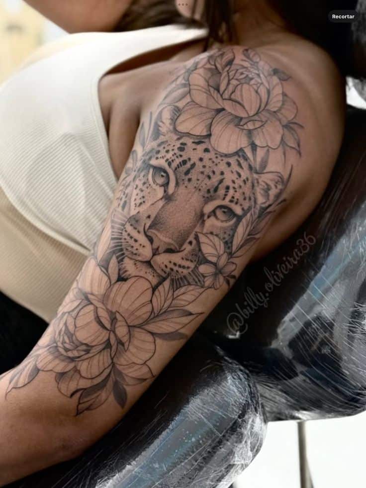 Floral and leopard tattoo sleeve on woman's arm, detailed black and grey ink art.