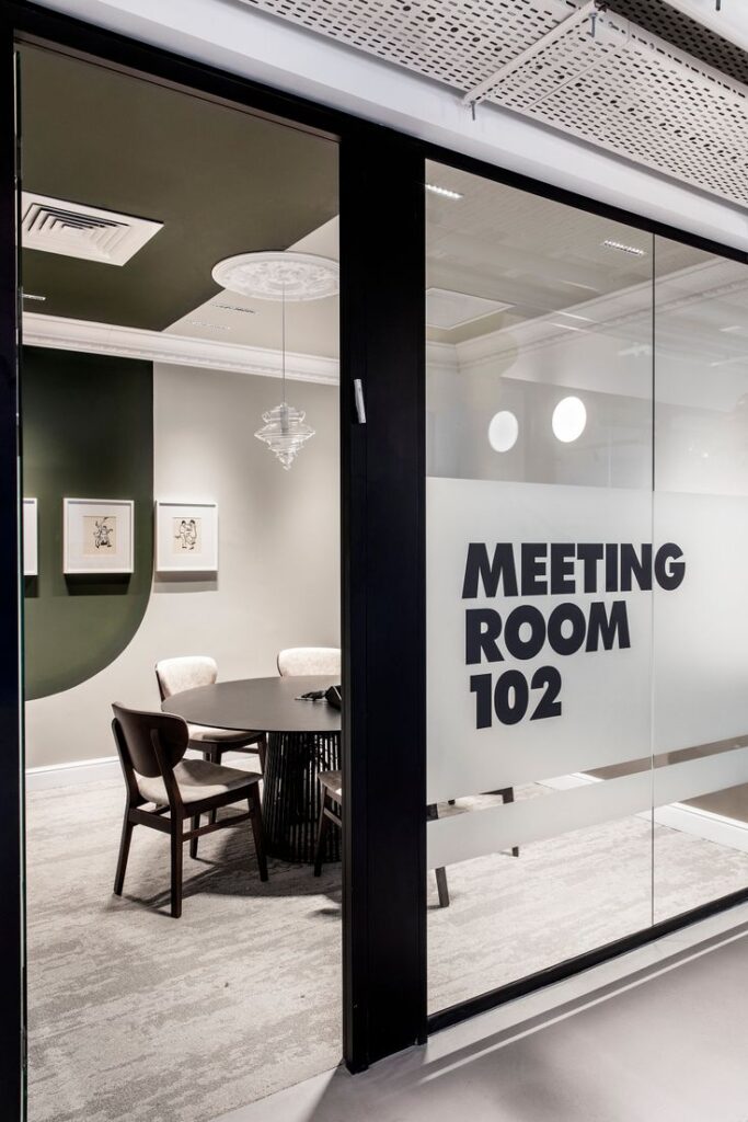 fea02d95c7c61c4acd8abc390d79648e Modern meeting room 102 with round table, padded chairs, and artwork on walls. Glass door with room number. | Sky Rye Design Modern meeting room 102 with round table, padded chairs, and artwork on walls. Glass door with room number.