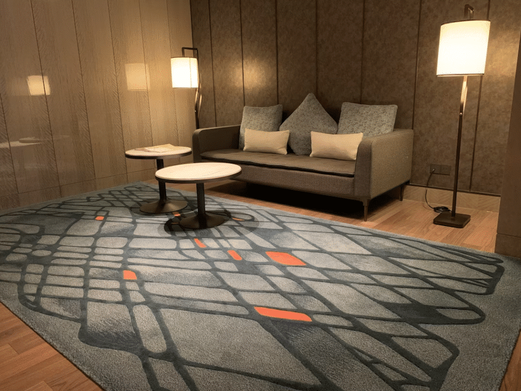 image1 Modern lounge with gray sofa, two round tables, abstract rug, and elegant floor lamps. | Sky Rye Design Modern lounge with gray sofa, two round tables, abstract rug, and elegant floor lamps.