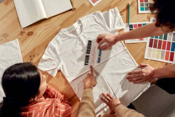 istockphoto-1226094814-612x612 Design team collaborates on custom t-shirt print, surrounded by color samples on a wooden table. | Sky Rye Design Design team collaborates on custom t-shirt print, surrounded by color samples on a wooden table.