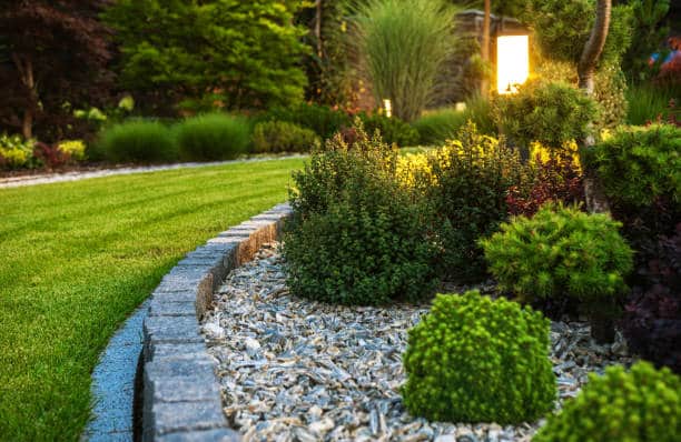 istockphoto-1467597986-612x612 Modern garden with manicured lawn, stone border, and lit pathway lamp at dusk. | Sky Rye Design Modern garden with manicured lawn, stone border, and lit pathway lamp at dusk.