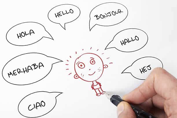 Drawing of a smiling person surrounded by speech bubbles with hello in various languages, emphasizing multilingual greetings.