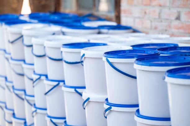 istockphoto-2157728307-612x612-1 Stacks of white plastic buckets with blue lids in an industrial setting. | Sky Rye Design Stacks of white plastic buckets with blue lids in an industrial setting.