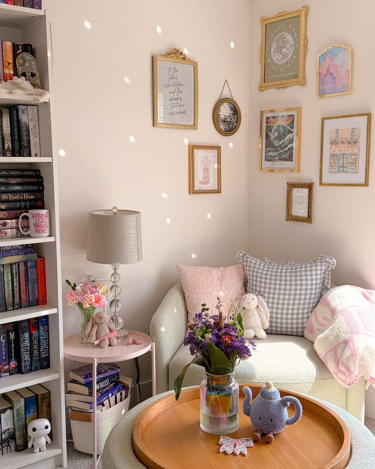 Cozy reading nook with bookshelves, floral decor, plush toys, and framed art on pastel-colored walls.