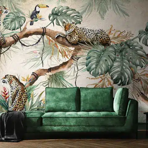 Luxurious green sofa with jungle-themed wallpaper featuring leopards and a toucan on a tree branch.