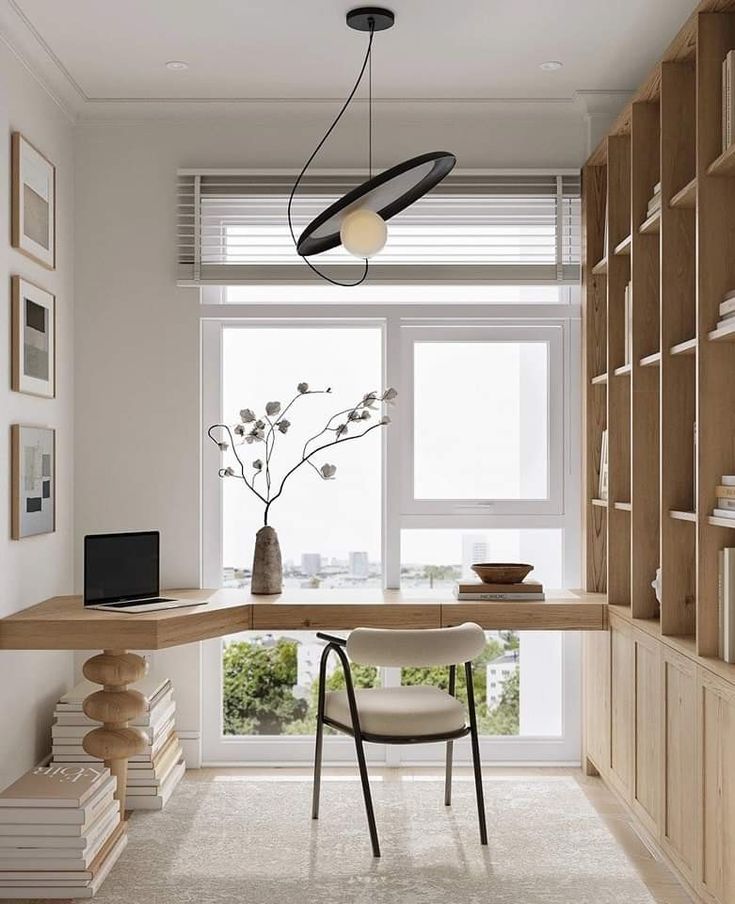 Minimalist home office with L-shaped wooden desk, modern chair, unique pendant light, and large window view.