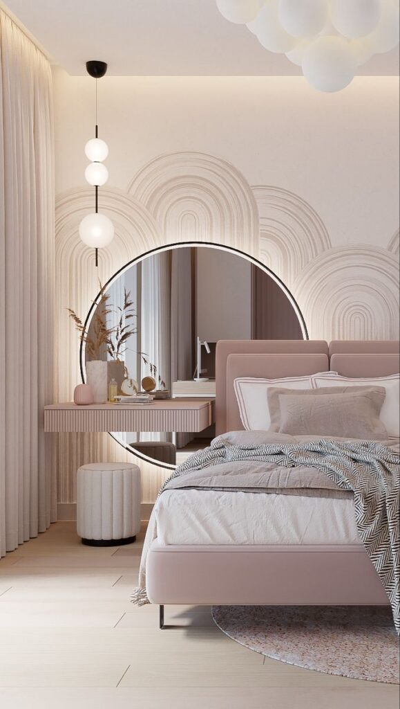 Modern bedroom with pink bed, round mirror, pendant lights, and stylish decor. Cozy and elegant interior design.