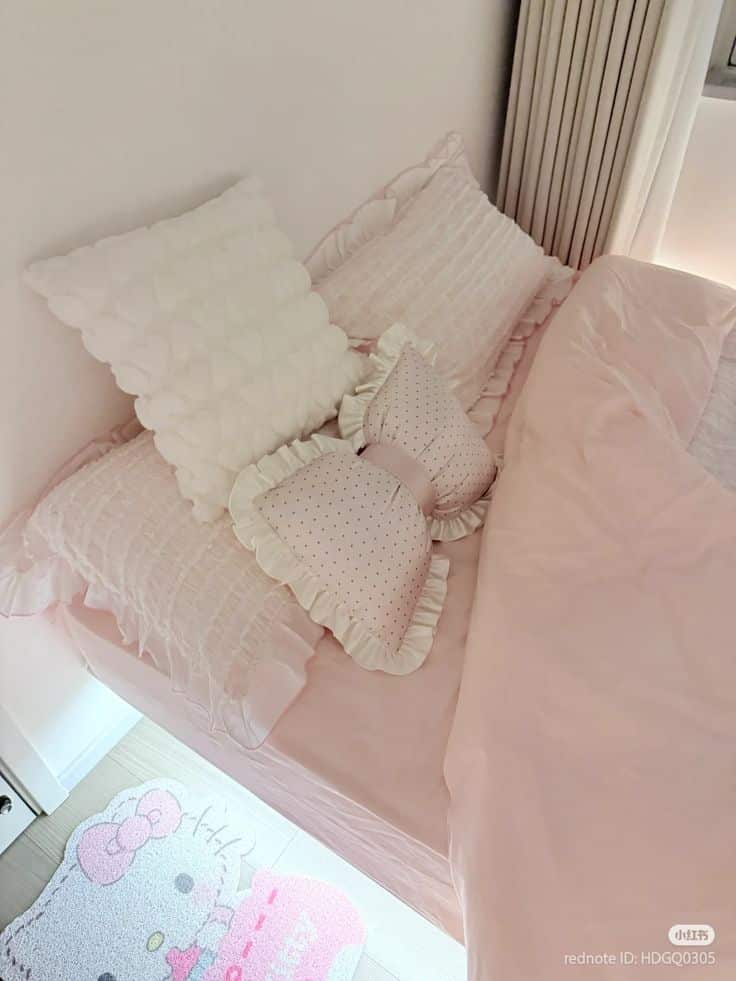 Cozy bedroom setup with pink and white pillows, ruffled bedding, and a cute character-themed rug on the floor.