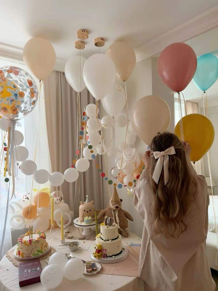 Woman arranging balloons at a birthday party with cakes and colorful decorations. Birthday crafts
