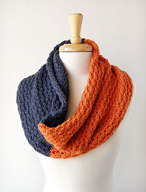 Two-tone knit infinity scarf in navy and orange draped on a mannequin.