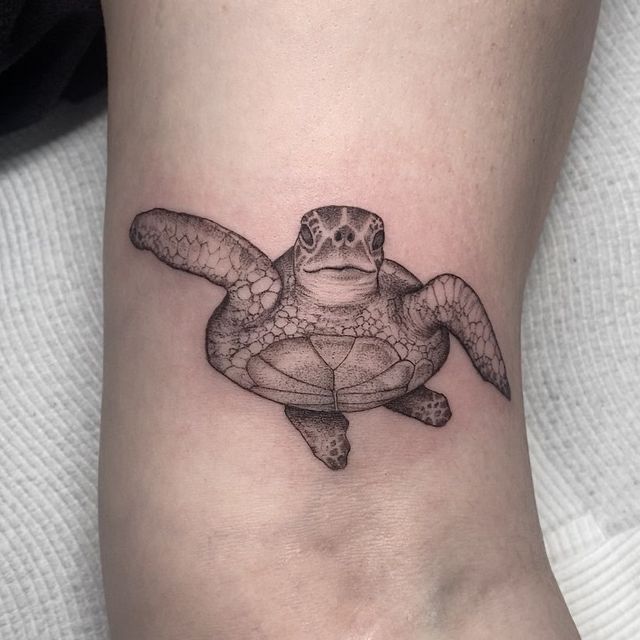 Realistic turtle tattoo on skin, showcasing intricate details and shading.