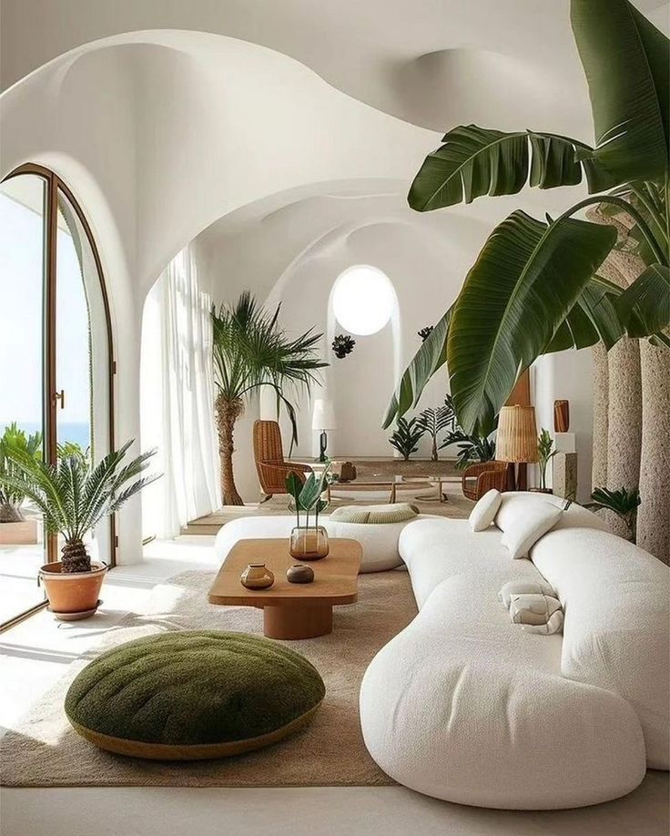Modern living room with curved sofa, indoor plants, and natural light through large windows, creating a serene ambiance.