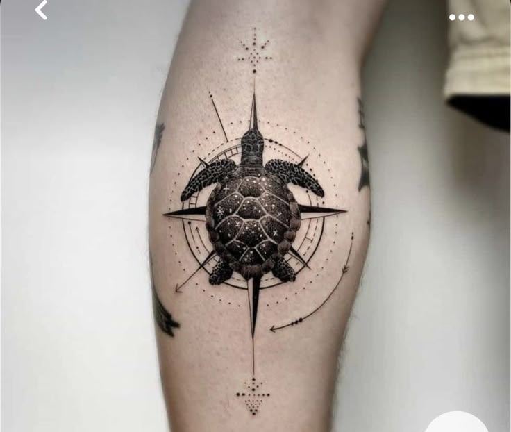 Turtle tattoo with compass design on leg, featuring intricate dot and line details, symbolizing guidance and journey.