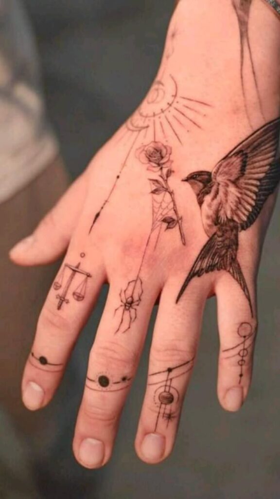 Hand with intricate tattoos featuring a bird, scales, rose, and abstract designs on fingers and back of palm.