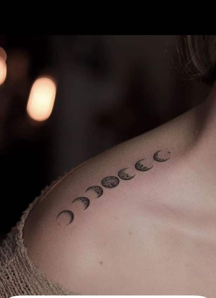 Lunar phases tattoo on shoulder, showing moon cycle in artistic black ink design.