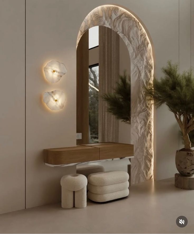 Modern interior with decorative arch, wooden console, plush stools, wall lights, and large plant in stylish decor.