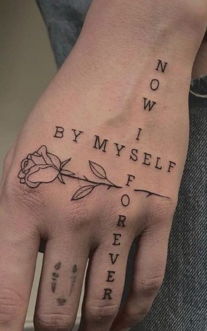 Tattoo on hand with a rose and BY MYSELF NOW and I FOREVER letters forming a cross.