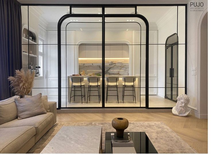 Modern open-plan living space with glass partition, chic kitchen island, and minimalist decor.