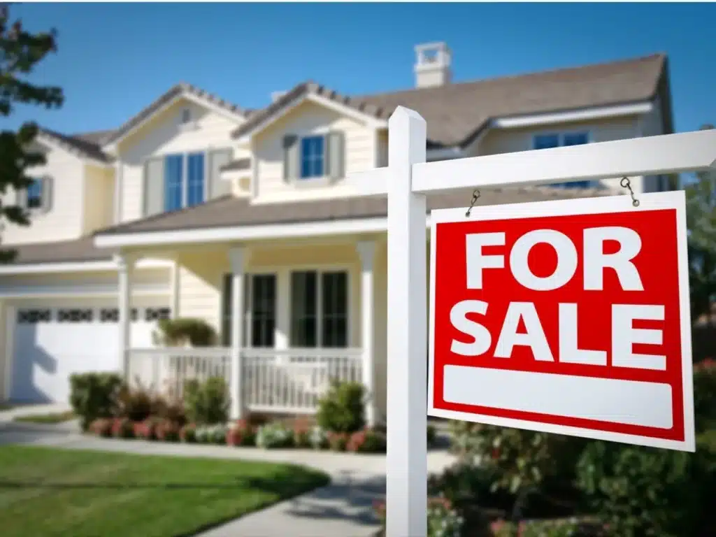 House for sale with front yard and For Sale sign in foreground, ideal for real estate listings.