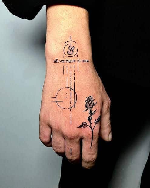 Hand tattoo with geometric design, rose, and all we have is now quote. Minimalist ink art.