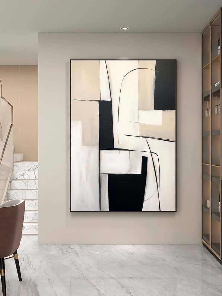 Abstract black and beige painting on a modern wall in a sleek, minimalist room with marble floors and stairs.