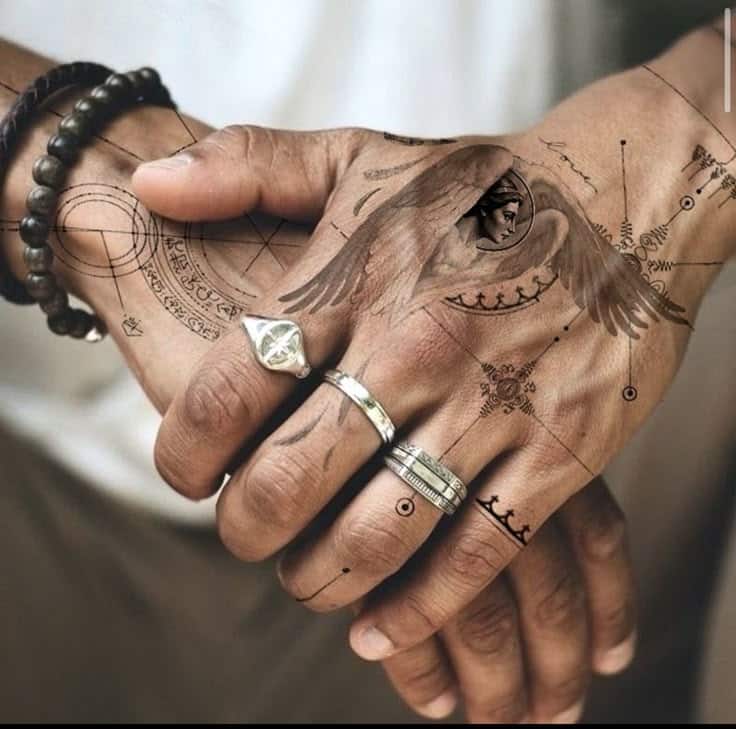 Hands with intricate geometric tattoos and rings, featuring an eye with wings design.