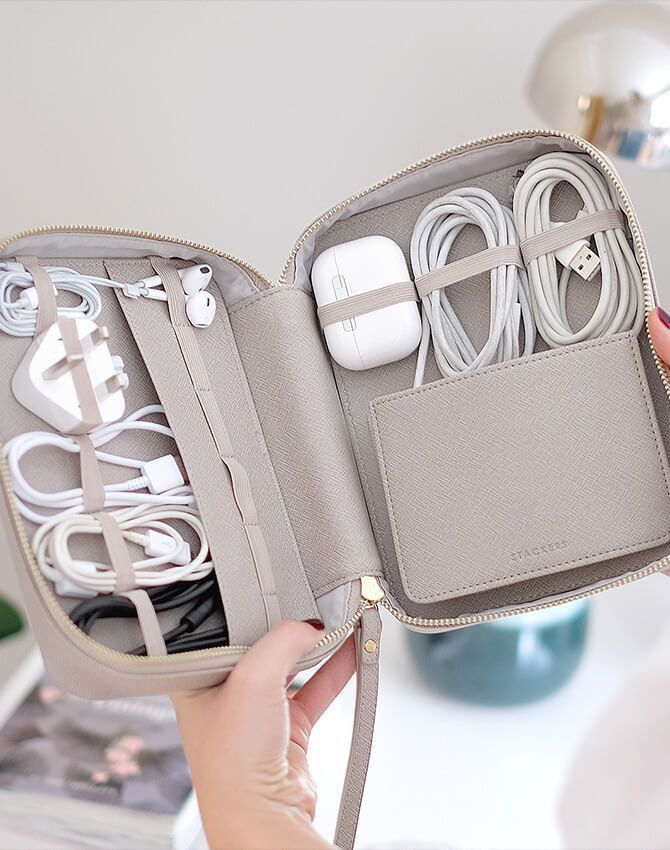 Open travel organizer with compartments holding cables, charger, and earbuds, perfect for tech accessories.