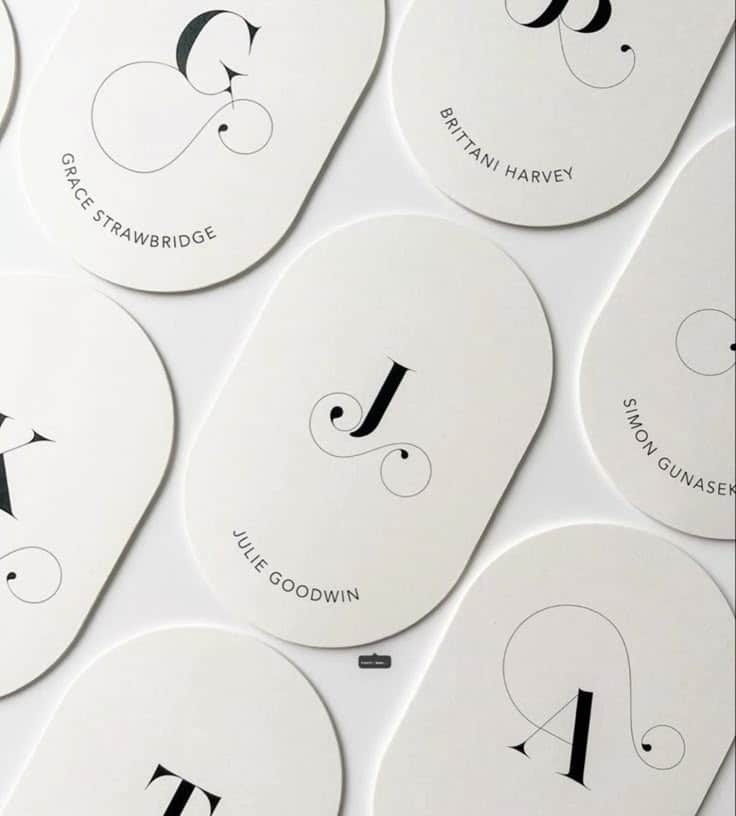 Elegant oval cards with initials and names, featuring stylish typography on a white background.
