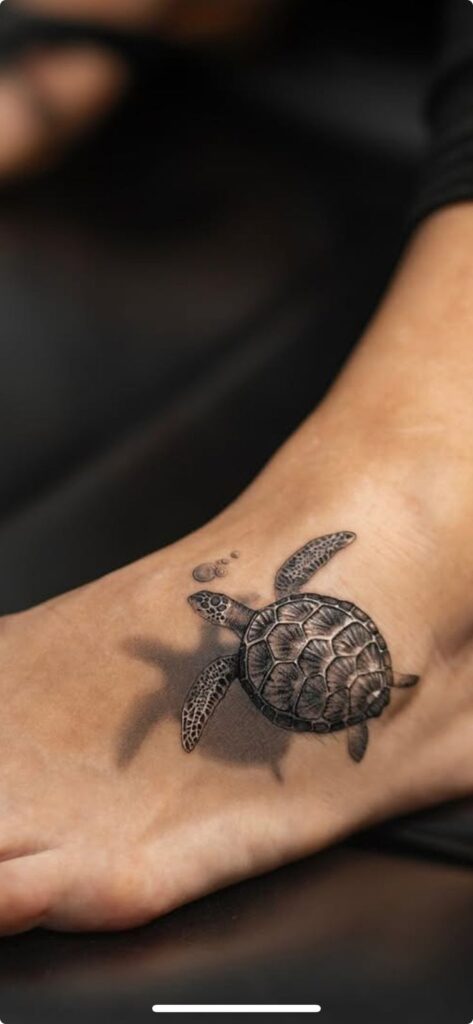 Realistic turtle tattoo on foot, detailed sea life design.