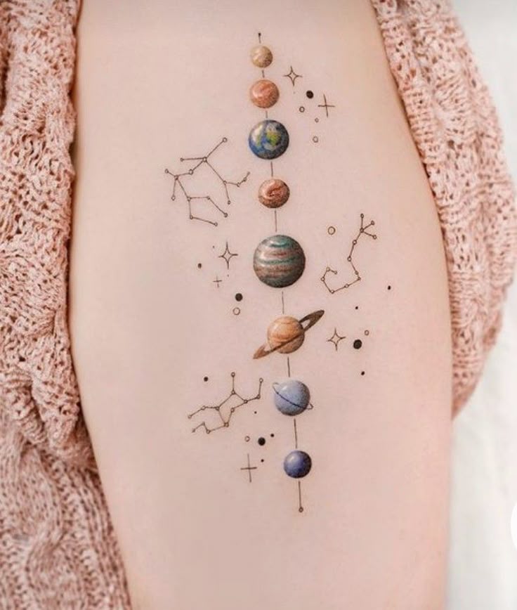 Tattoo of planets and constellations on skin, showcasing a solar system design with celestial elements.