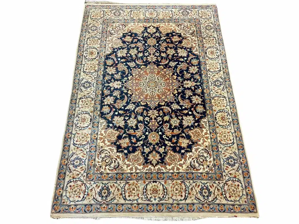 Intricate Persian rug with ornate floral patterns and a rich navy blue and cream color scheme.