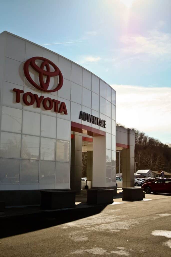 Toyota dealership entrance with clear sky, showcasing modern architecture and branding.