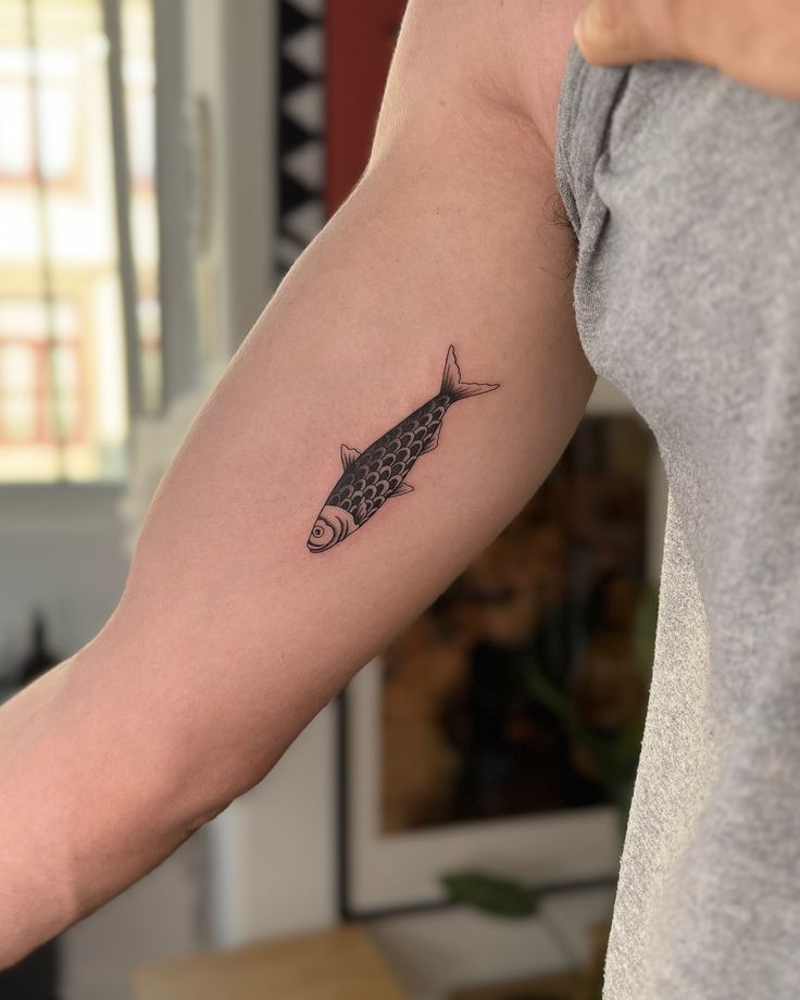 An unchanging symbol of Portugal 🐟😊__sardine tattoo tatuagem tattooporto portotattoo tattoofish Arm with a detailed fish tattoo in black ink, tattooed on the inner forearm, showcased in natural indoor light. | Sky Rye Design Arm with a detailed fish tattoo in black ink, tattooed on the inner forearm, showcased in natural indoor light.