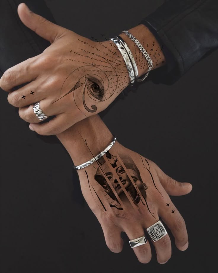 Close-up of hands with artistic tattoos, wearing silver rings and bracelets on a black background.