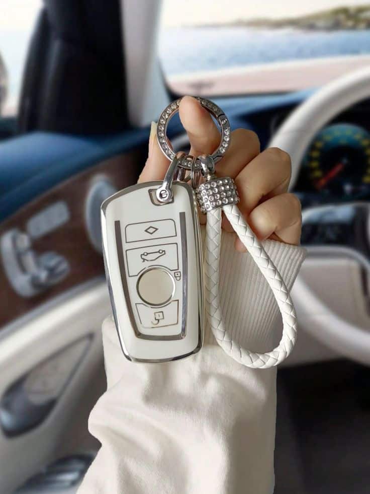 BMW Silver White Key Case Luxury car key with elegant keychain inside vehicle, showcasing modern automotive design and sophistication. | Sky Rye Design Luxury car key with elegant keychain inside vehicle, showcasing modern automotive design and sophistication.