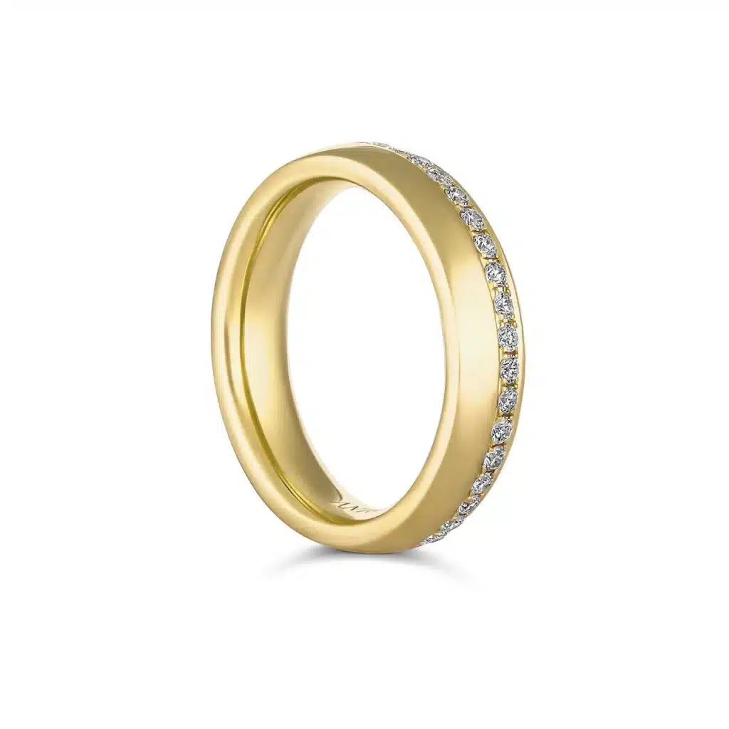 Elegant gold wedding band adorned with sparkling diamonds on top.