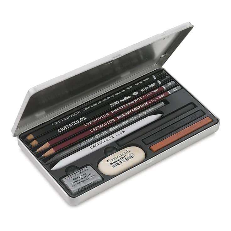 Open metal case with assorted art pencils, eraser, and charcoal sticks for drawing and sketching.
