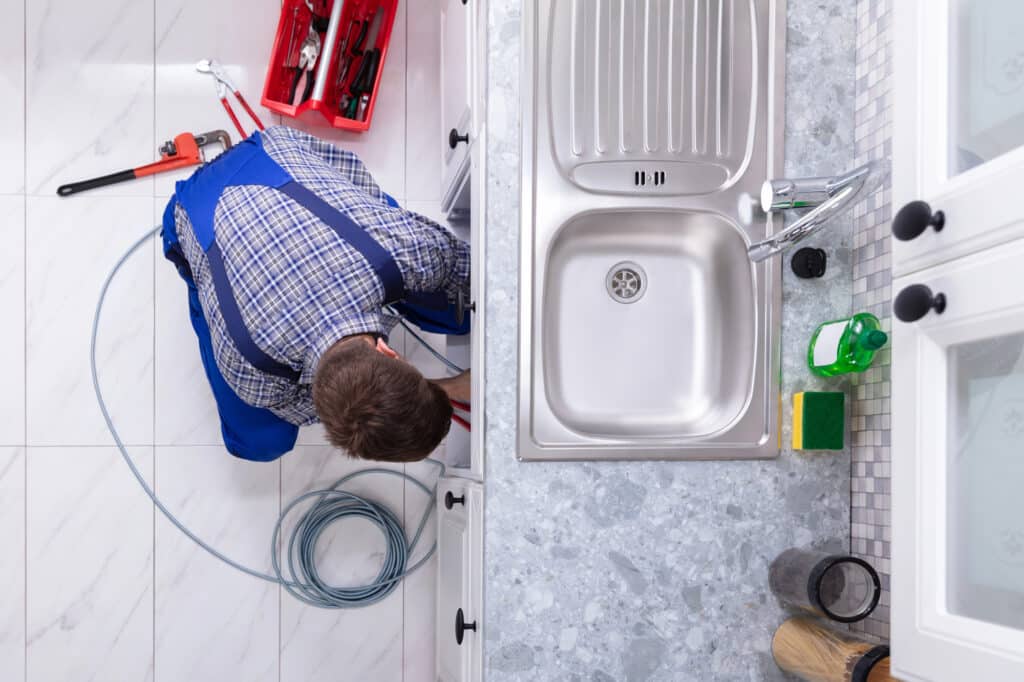 Depositphotos_240813346_L Plumber repairing kitchen sink with tools, viewed from above. | Sky Rye Design Plumber repairing kitchen sink with tools, viewed from above.