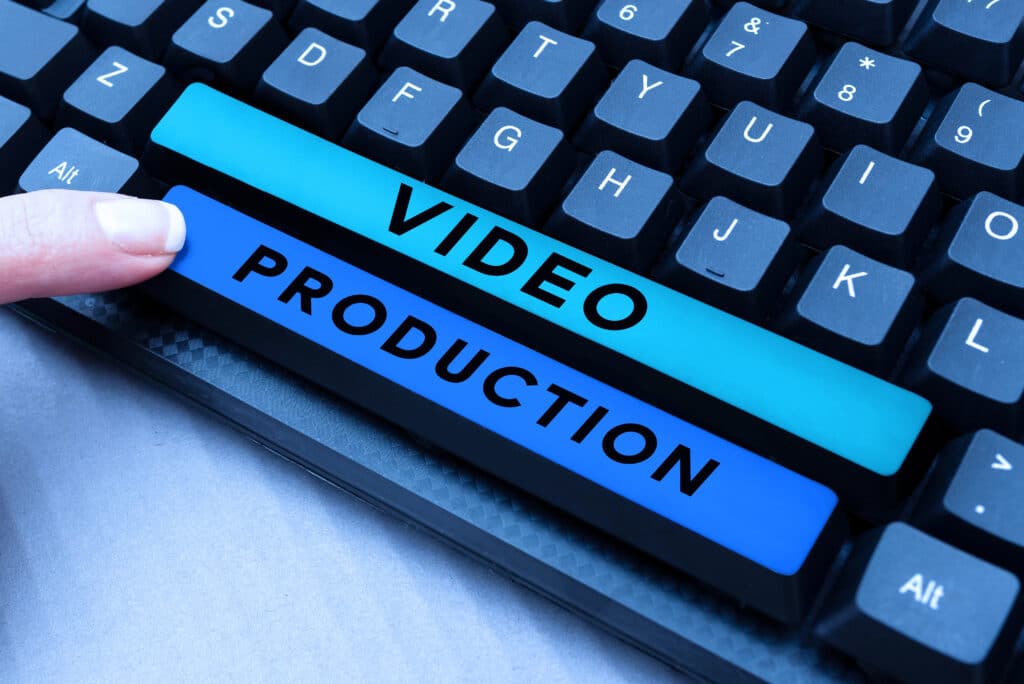 Finger pressing keys labeled 'Video Production' on a computer keyboard, symbolizing video content creation.