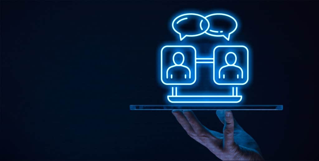 Neon icons of connected people with speech bubbles over a tablet, representing digital communication and networking.