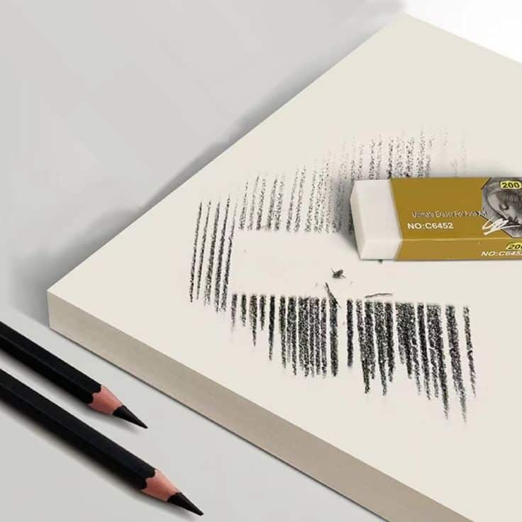 Eraser removing pencil lines on paper with two black pencils nearby. Ideal for drawing and sketching activities.