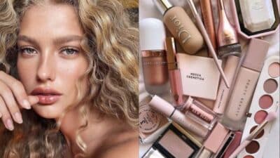 Woman with curly hair and flawless skin; a variety of beauty products like foundation and lipstick arranged artfully.