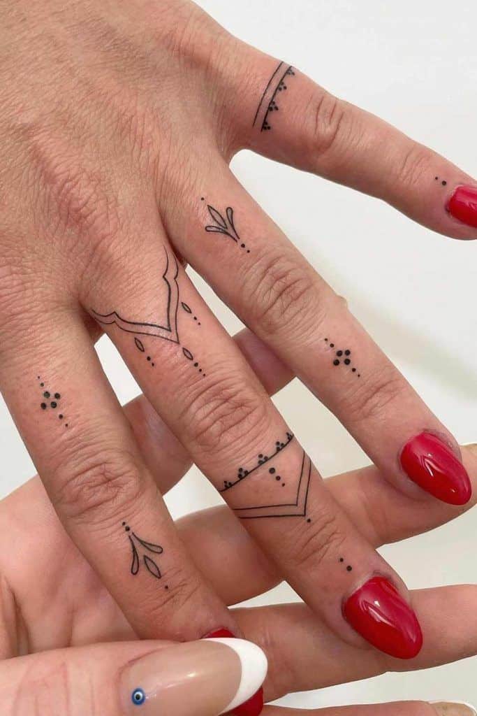 Hand Tattoos For Women You Will Want To Get Inked Delicate finger tattoos with geometric designs and red nails on a hand, showcasing minimalist tattoo art. | Sky Rye Design Delicate finger tattoos with geometric designs and red nails on a hand, showcasing minimalist tattoo art.