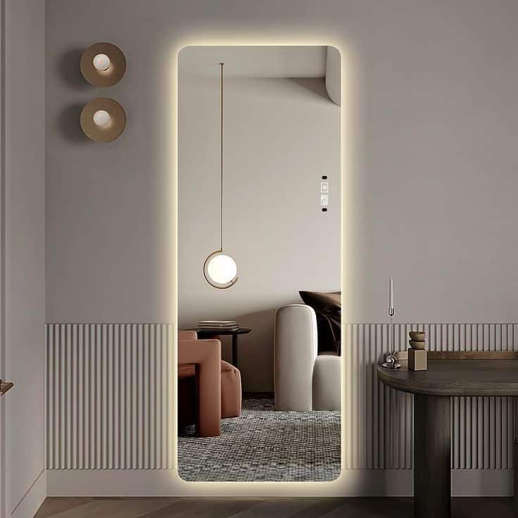 Modern interior with illuminated mirror, reflecting stylish decor and furniture in a cozy room.