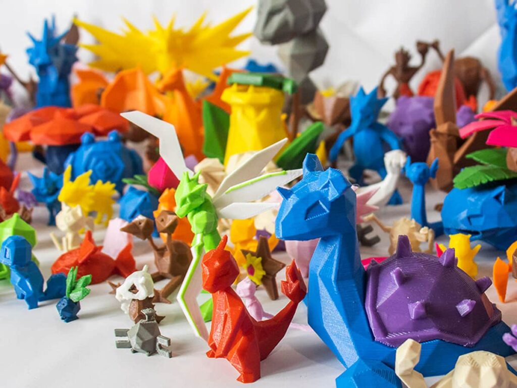 Colorful 3D-printed low-poly models of various fantastical creatures on display.