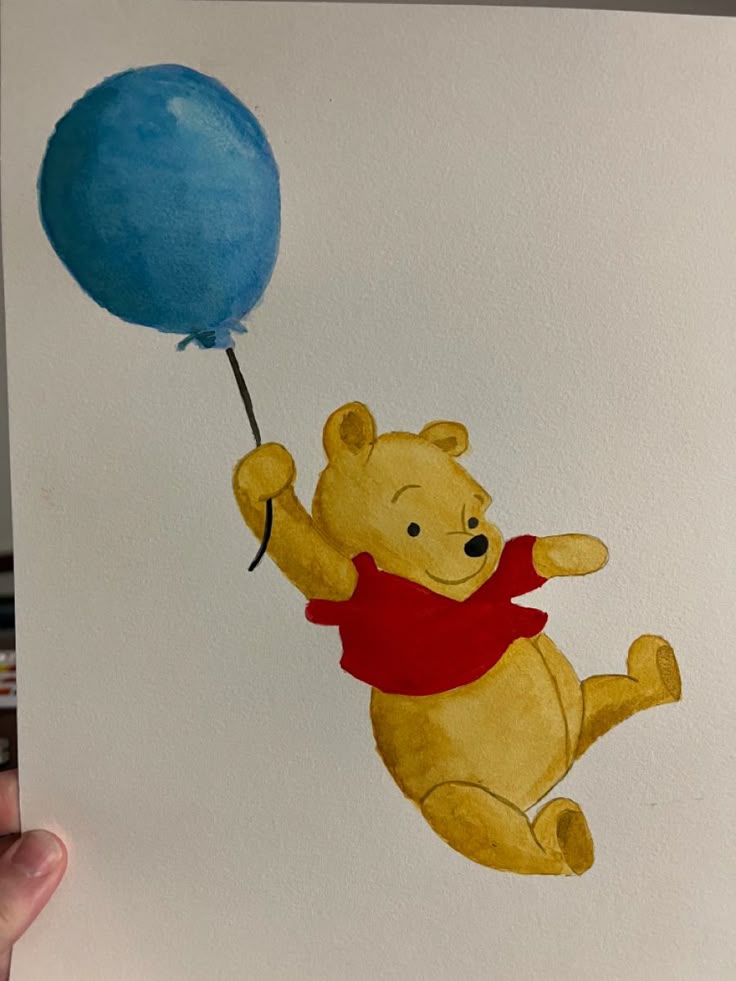 Illustration of a cheerful bear in a red shirt floating with a blue balloon, hand drawn on white paper.