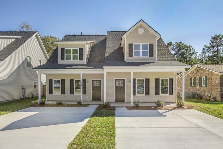 Real Estate Photography - Moody Branding Boutique Modern two-story house with a porch, large windows, and a driveway in a suburban neighborhood. | Sky Rye Design Modern two-story house with a porch, large windows, and a driveway in a suburban neighborhood.