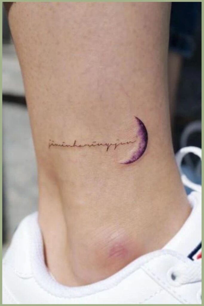 Minimal crescent moon tattoo with script on ankle above white sneaker.